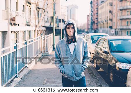 Man in urban area wearing hooded top and headphones looking at camera View Large Photo Image Stock Photography - Man in urban area wearing hooded top and headphones looking at camera. Fotosearch