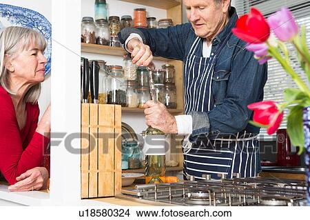 Man opening bottle of wine in kitchen View Large Photo Image Picture - Man opening bottle of wine in kitchen. Fotosearch
