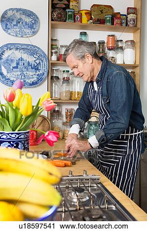 Stock Image - Man preparing food in kitchen. Fotosearch