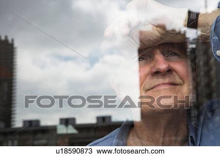 Man smiling and leaning head against window View Large Photo Image Stock Image - Man smiling and leaning head against window. Fotosearch