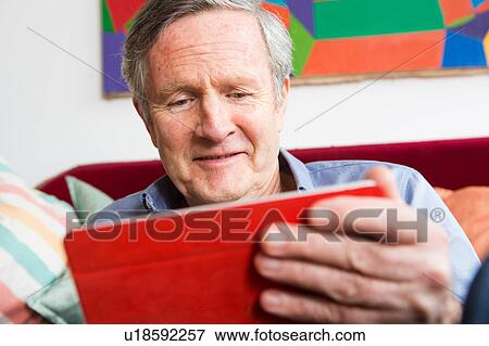 Stock Photo - Man using digital tablet at home. Fotosearch