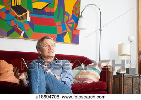Stock Photo - Man using digital tablet at home. Fotosearch