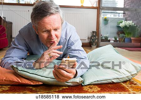 Man using smartphone on floor View Large Photo Image Stock Photo - Man using smartphone on floor. Fotosearch