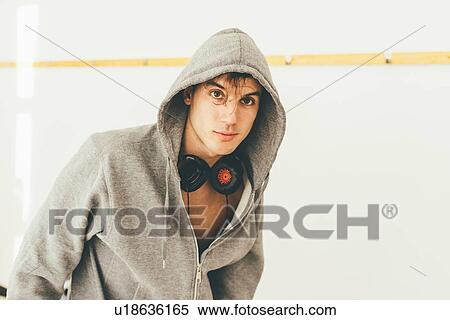Stock Photography - Man wearing hooded top and headphones looking at camera. Fotosearch