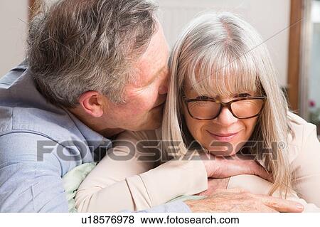 Man whispering into wife's ear View Large Photo Image Stock Photo - Man whispering into wife's ear. Fotosearch