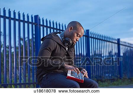 Man with headphones using handheld keyboard View Large Photo Image Stock Photo - Man with headphones using handheld keyboard. Fotosearch