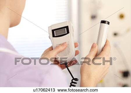 Stock Image - Midwife with a doppler monitor. Fotosearch