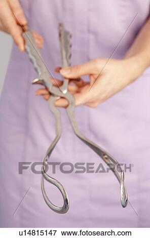 Stock Photo - Midwife with obstetric forceps. Fotosearch