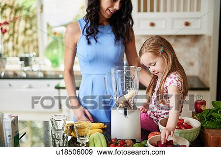 Stock Photo - Mother and daughter making smoothies. Fotosearch