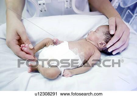Stock Image - Nurse and premature baby. Fotosearch