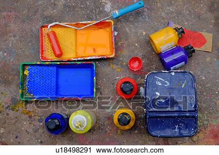 Stock Image - Overhead view of blue and yellow paint trays and paint roller. Fotosearch