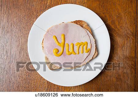 Overhead view of the word yum written on ham on toast in mustard View Large Photo Image Stock Photograph - Overhead view of the word yum written on ham on toast in mustard. Fotosearch