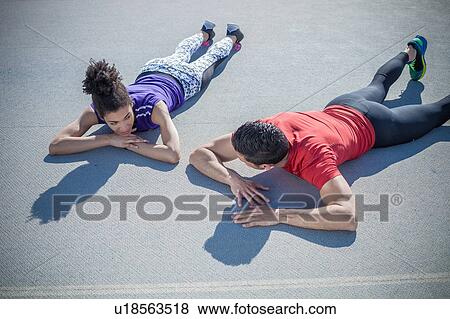 Overhead view of young man and woman training, taking a break on asphalt View Large Photo Image Stock Photo - Overhead view of young man and woman training, taking a break on asphalt. Fotosearch