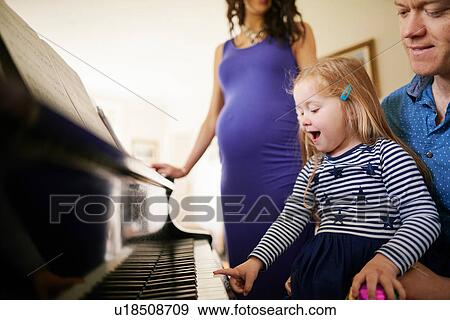Parents teaching daughter to play piano View Large Photo Image Stock Photo - Parents teaching daughter to play piano. Fotosearch