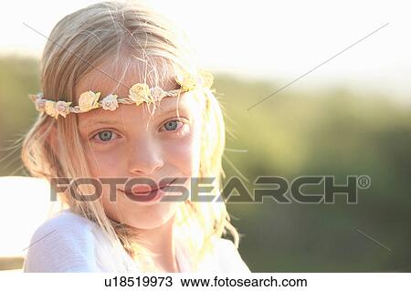 Stock Image - Portrait of blond girl wearing flower headband, Buonconvento, Tuscany, Italy. Fotosearch