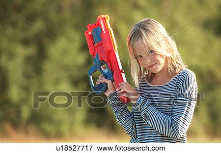 Stock Photo - Portrait of girl holding water gun, Buonconvento, Tuscany, Italy. Fotosearch