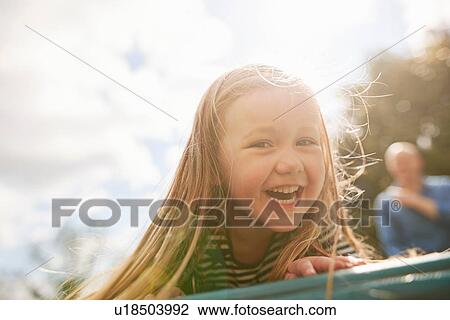 Stock Image - Portrait of girl looking at camera smiling. Fotosearch