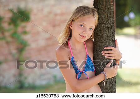 Portrait of girl wearing bikini top leaning against tree, Buonconvento, Tuscany, Italy View Large Photo Image Stock Image - Portrait of girl wearing bikini top leaning against tree, Buonconvento, Tuscany, Italy. Fotosearch