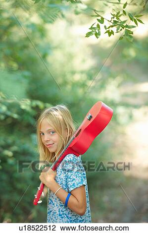 Portrait of girl with red ukulele in woodland, Buonconvento, Tuscany, Italy View Large Photo Image Stock Image - Portrait of girl with red ukulele in woodland, Buonconvento, Tuscany, Italy. Fotosearch
