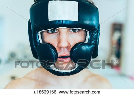 Stock Photograph - Portrait of man wearing head protector looking at camera. Fotosearch