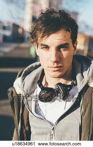 Portrait of man wearing hooded top and headphones looking at camera View Large Photo Image Stock Image - Portrait of man wearing hooded top and headphones looking at camera. Fotosearch