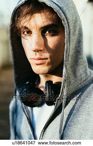 Portrait of man wearing hooded top and headphones looking at camera View Large Photo Image Stock Photo - Portrait of man wearing hooded top and headphones looking at camera. Fotosearch