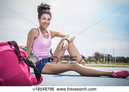 Portrait of young woman training, taking a break on running track View Large Photo Image Stock Photograph - Portrait of young woman training, taking a break on running track. Fotosearch