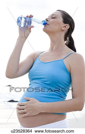 Picture - Pregnant woman drinking water. Fotosearch