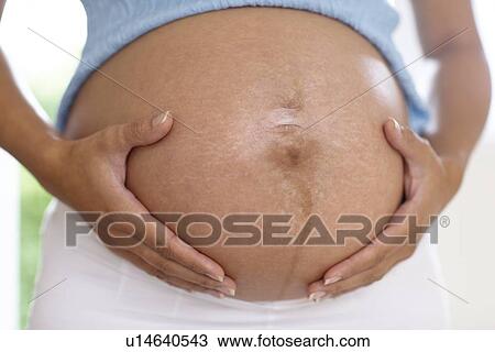 Stock Image - Pregnant woman's abdomen. Fotosearch