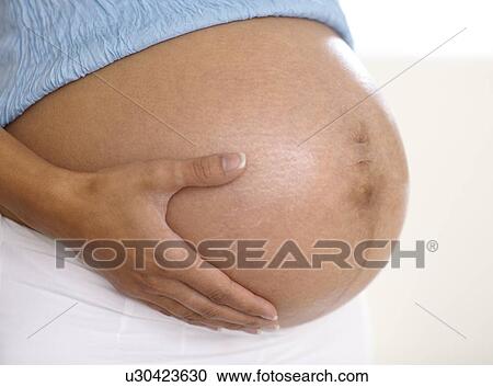 Stock Image - Pregnant woman's abdomen. Fotosearch
