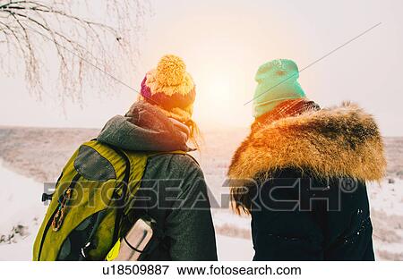 Stock Photo - Rear view of couple wearing knit hats looking away at view. Fotosearch