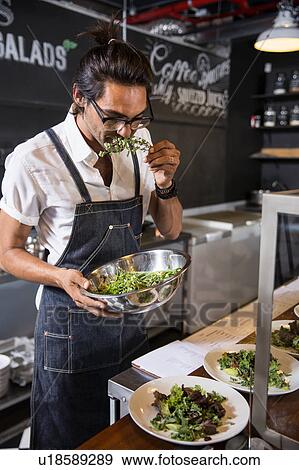 Stock Photo - Restaurateur smelling salad leaf. Fotosearch