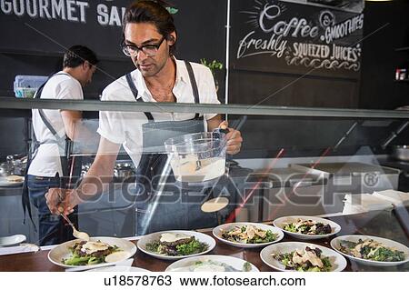 Restaurateurs preparing salad behind service counter View Large Photo Image Stock Image - Restaurateurs preparing salad behind service counter. Fotosearch