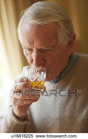 Stock Photography - Senior man drinking whiskey. Fotosearch