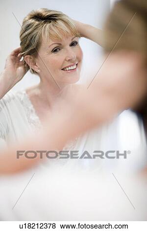 Senior woman doing her hair View Large Photo Image Stock Photo - Senior woman doing her hair. Fotosearch