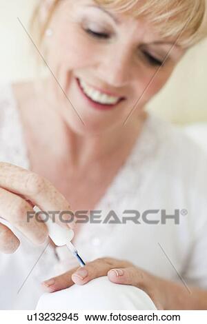 Senior woman painting her nails View Large Photo Image Stock Photography - Senior woman painting her nails. Fotosearch