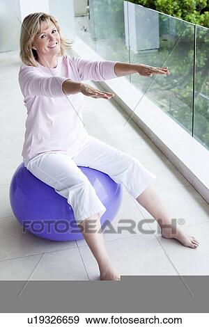 Senior woman using an exercise ball View Large Photo Image Stock Photo - Senior woman using an exercise ball. Fotosearch