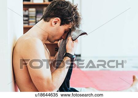 Stock Photography - Side view of man wiping brow with towel. Fotosearch