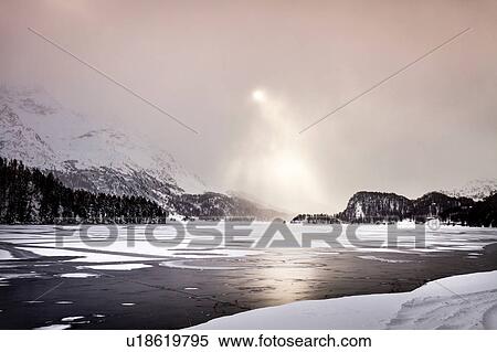 Sunbeams shining on frozen lake and snow covered mountains, Engadin, Switzerland View Large Photo Image Stock Photography - Sunbeams shining on frozen lake and snow covered mountains, Engadin, Switzerland. Fotosearch