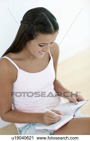 Stock Image - Teenage girl and her diary. Fotosearch