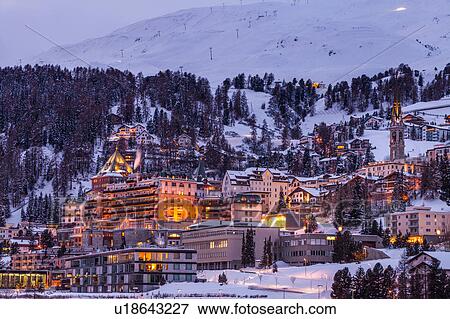 Village beneath mountain on snow covered landscape illuminated in the evening, Sankt Moritz, Switzerland View Large Photo Image Stock Photo - Village beneath mountain on snow covered landscape illuminated in the evening, Sankt Moritz, Switzerland. Fotosearch