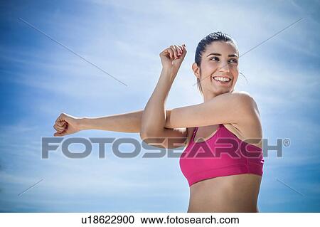 Stock Image - Woman doing arm stretching exercise. Fotosearch