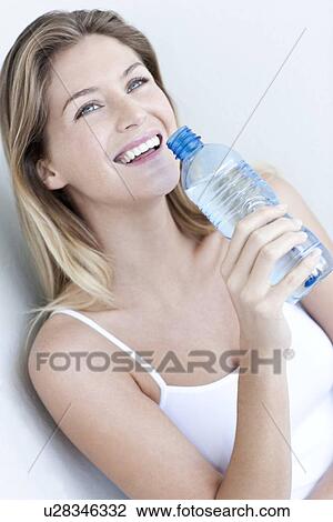Stock Image - Woman drinking bottled water. Fotosearch