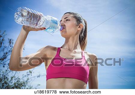 Woman drinking water from bottle View Large Photo Image Stock Photo - Woman drinking water from bottle. Fotosearch