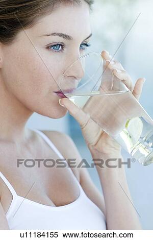 Stock Photography - Woman drinking water with lime. Fotosearch