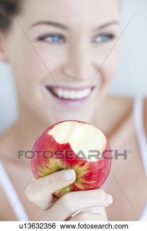 Woman eating an apple View Large Photo Image Stock Photograph - Woman eating an apple. Fotosearch
