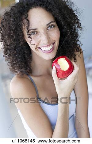 Stock Photography - Woman eating an apple. Fotosearch