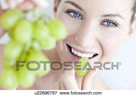 Stock Photo - Woman eating grapes. Fotosearch