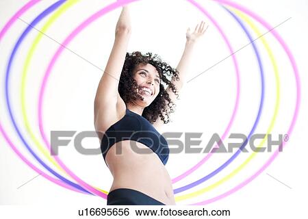 Stock Photograph - Woman hula-hooping. Fotosearch