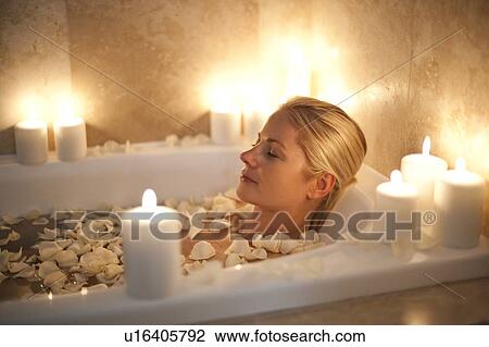 Stock Image - Woman relaxing in a bath. Fotosearch